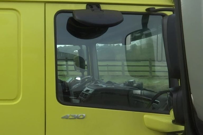Truck driver making card payments on his phone while driving